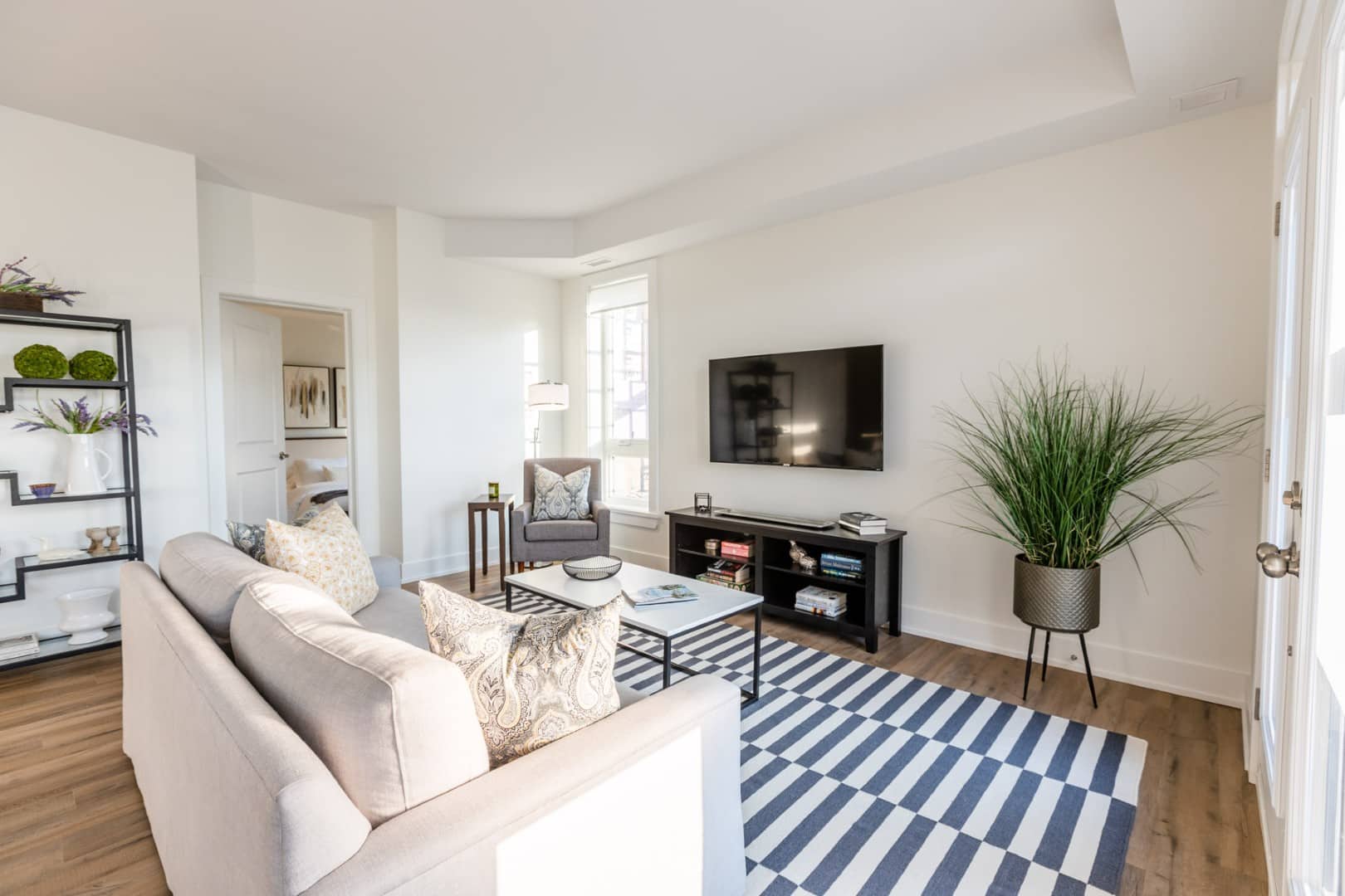 A bright, modern open-concept living space showcasing high-end hardwood flooring and designer lighting in a custom Ottawa home.