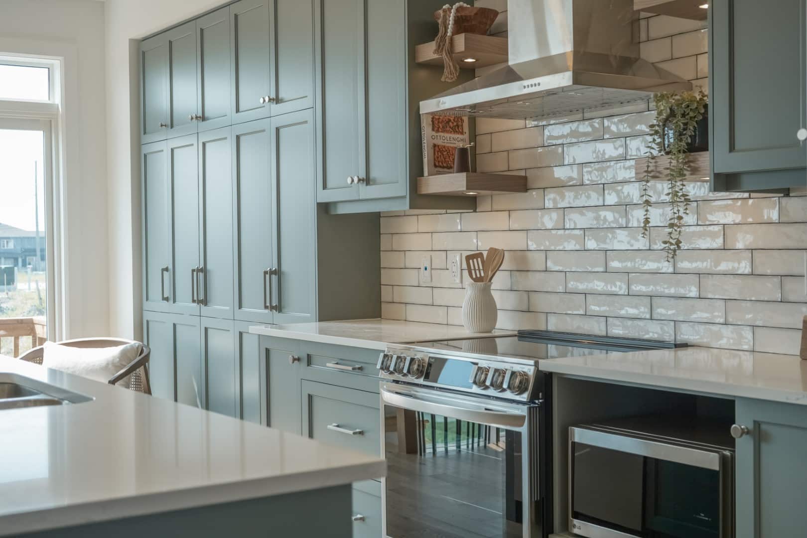 A designer residential kitchen featuring custom light-grey cabinetry and high-end stone finishes in a luxury Ottawa home.